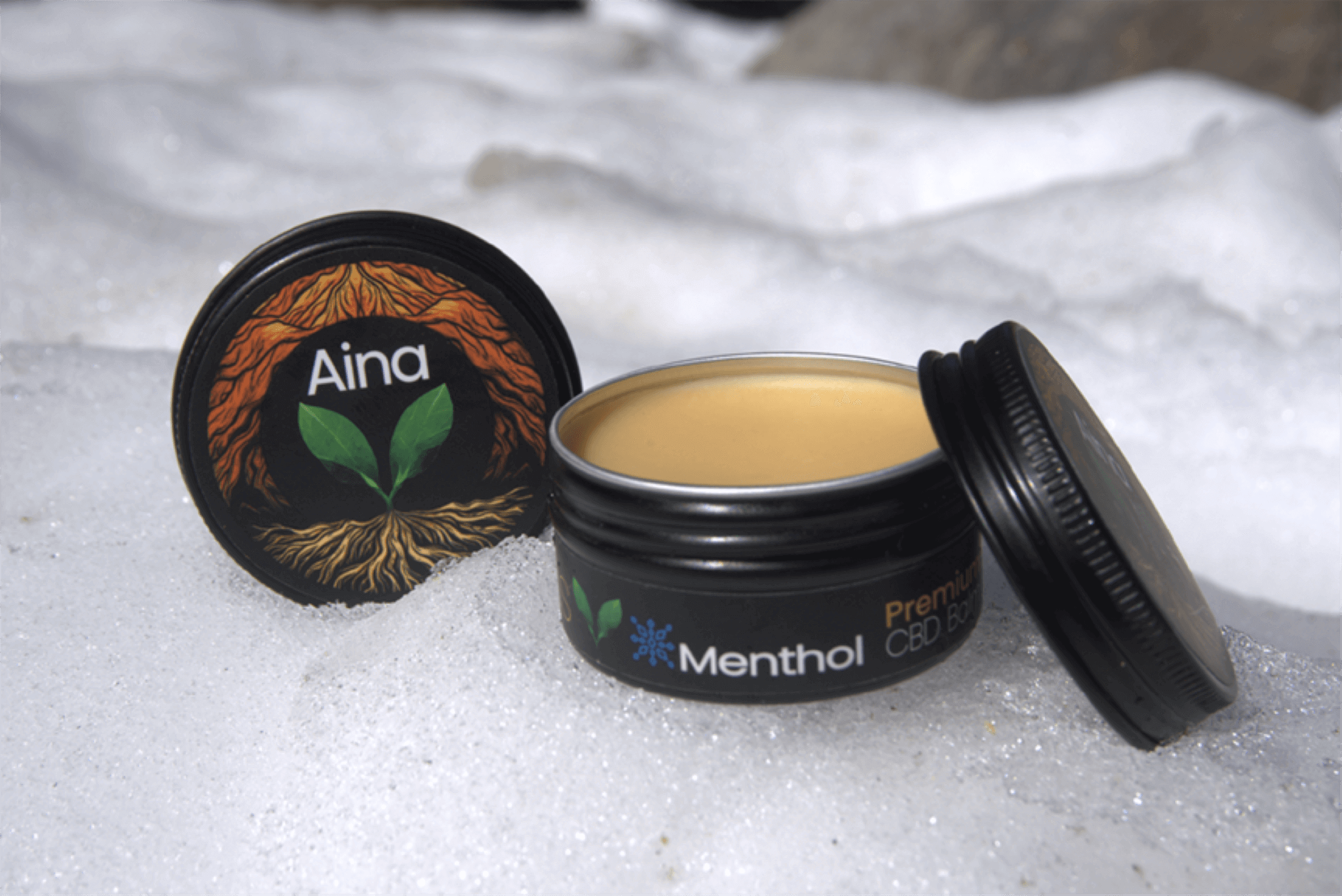 Aina Wellness Tropical CBD Topical Menthol Balm in its packaging, featuring a blend of Kauai-grown botanicals, including Noni fruit, carefully sourced from the Hindu Monastery in Kauai | CBD Direct Solutions
